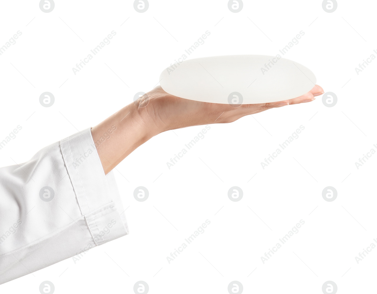 Photo of Doctor holding silicone implant for breast augmentation on white background. Cosmetic surgery