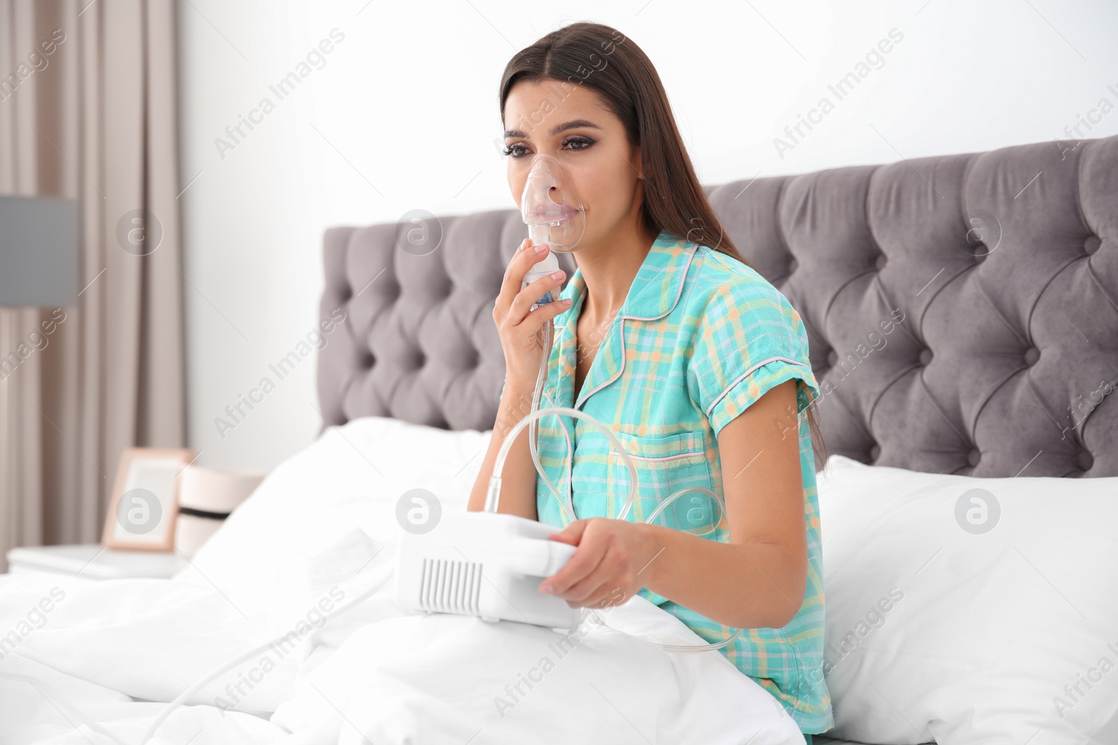 Photo of Woman with asthma machine in light bedroom