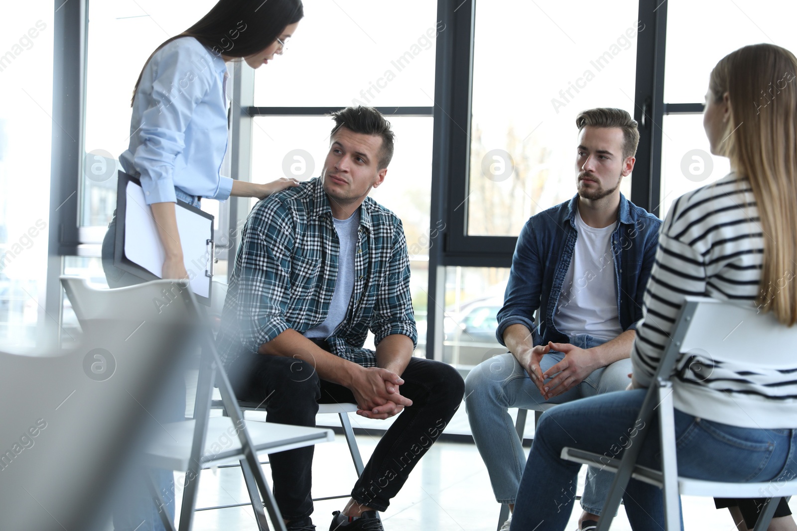 Photo of Psychotherapist working with patients in group therapy session indoors