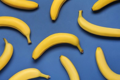 Ripe yellow bananas on blue background, flat lay