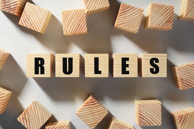 Photo of Word Rules made of wooden cubes with letters on white background, flat lay