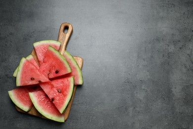 Photo of Slices of tasty ripe watermelon on grey table, top view. Space for text