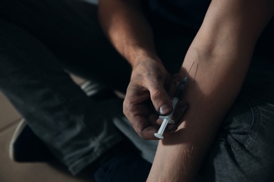 Photo of Male drug addict making injection, closeup of hands