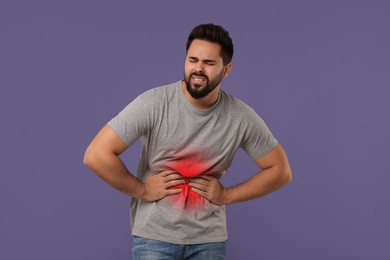 Image of Man suffering from abdominal pain on purple background