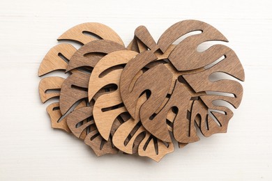 Leaf shaped wooden cup coasters on white table, flat lay