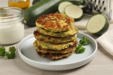 Delicious zucchini fritters served on wooden table