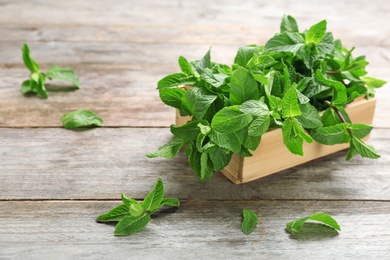 Photo of Wooden crate with fresh mint on table