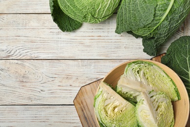 Flat lay composition with savoy cabbage and space for text on white wooden background