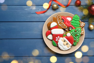 Different tasty Christmas cookies and decor on blue wooden table, flat lay. Space for text