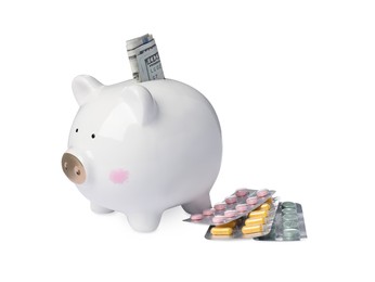 Photo of Piggy bank with money and pills on white background. Medical insurance
