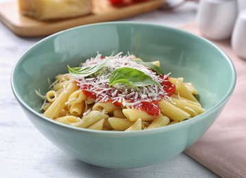 Photo of Delicious pasta with tomato sauce served on white wooden table, closeup