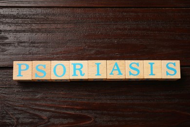 Word Psoriasis made of cubes with letters on wooden table, top view