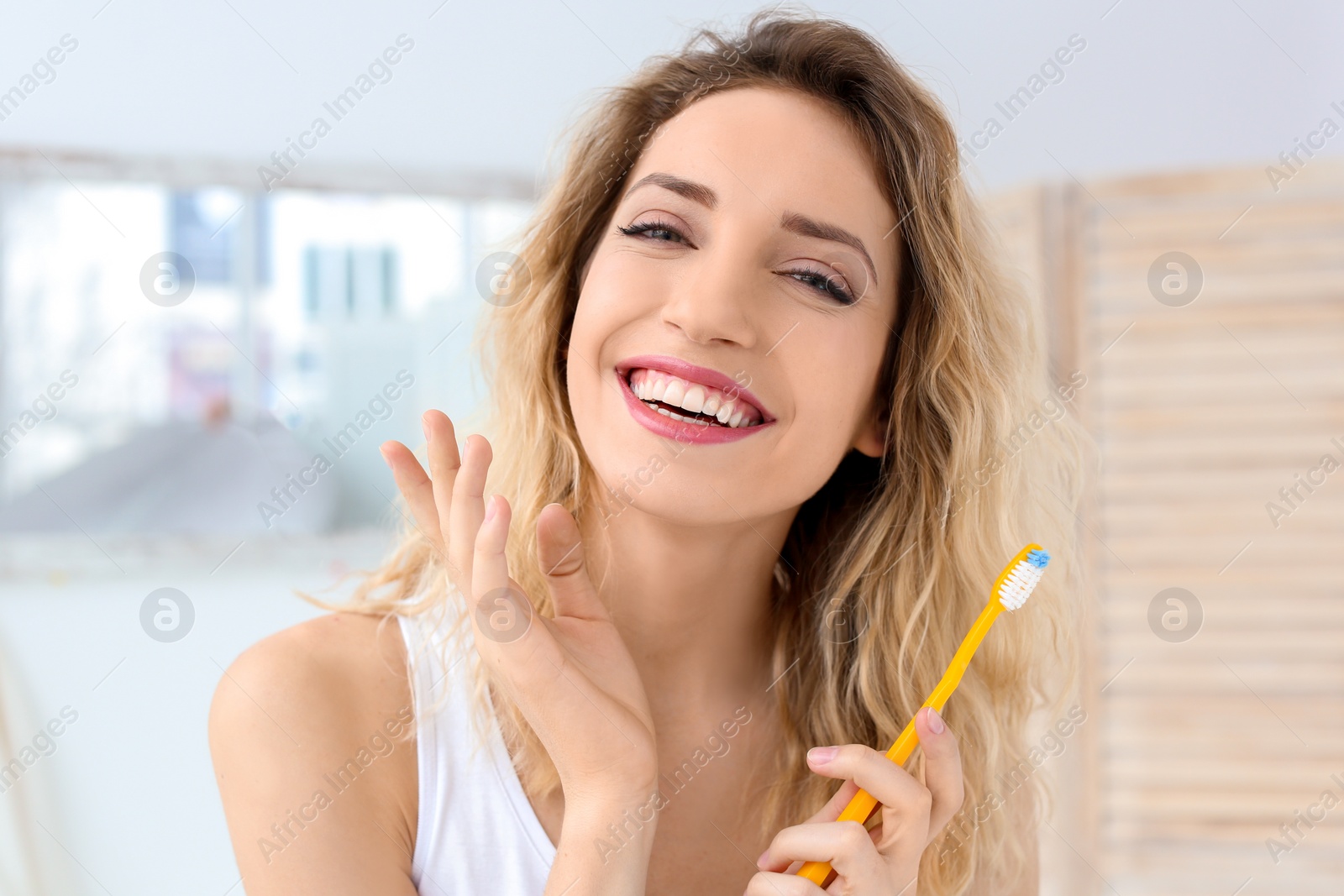 Photo of Young woman brushing her teeth in bathroom