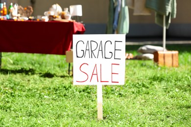 Photo of Sign Garage sale written on cardboard in yard