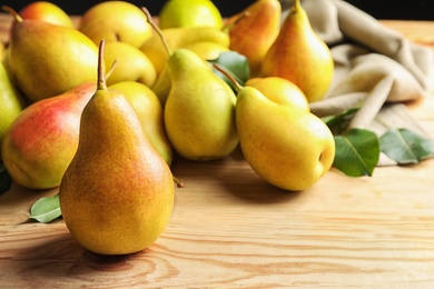 Photo of Ripe pears on wooden table. Space for text