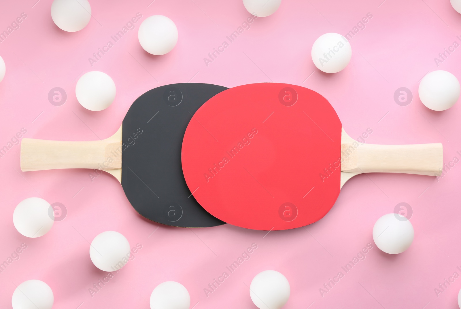 Photo of Ping pong rackets and balls on pink background, flat lay