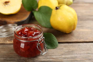 Photo of Delicious quince jam on wooden table, closeup