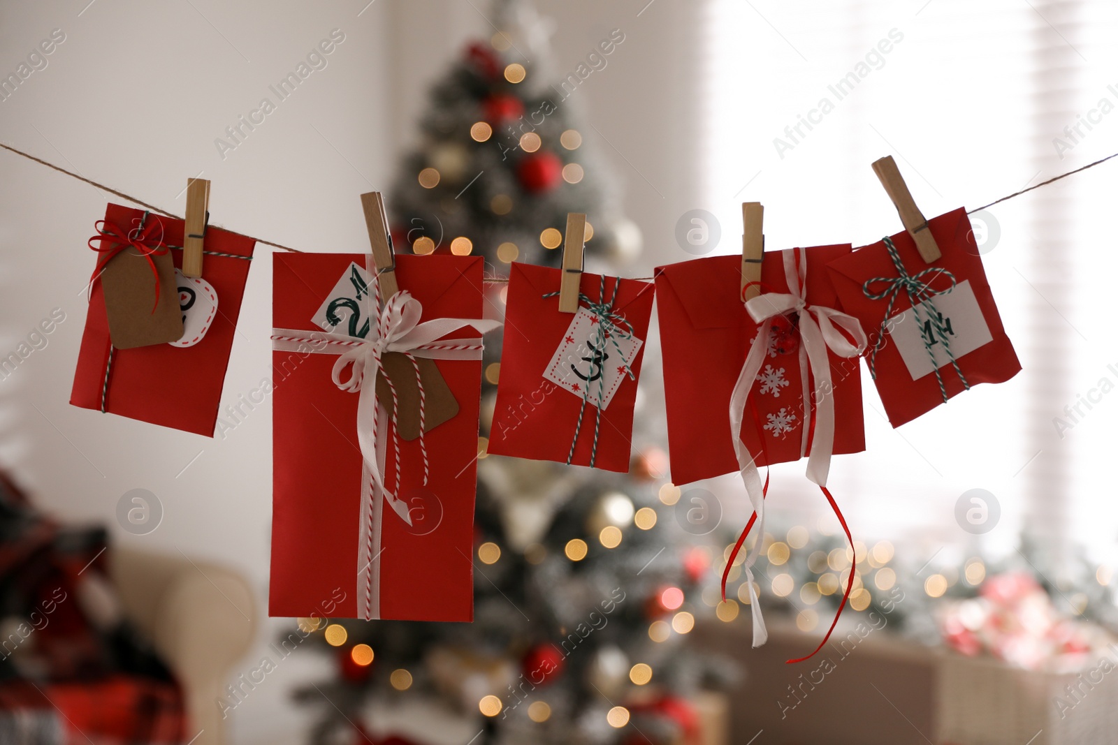 Photo of Christmas advent calendar with gifts hanging in room