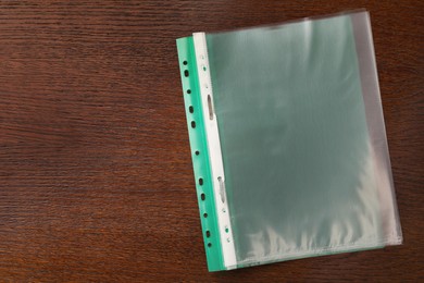 Photo of File folder with punched pockets on wooden table, top view. Space for text