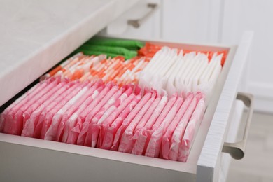 Photo of Storage of different feminine hygiene products in drawer indoors, closeup