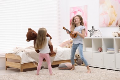 Photo of Cute little sisters having fun together at home