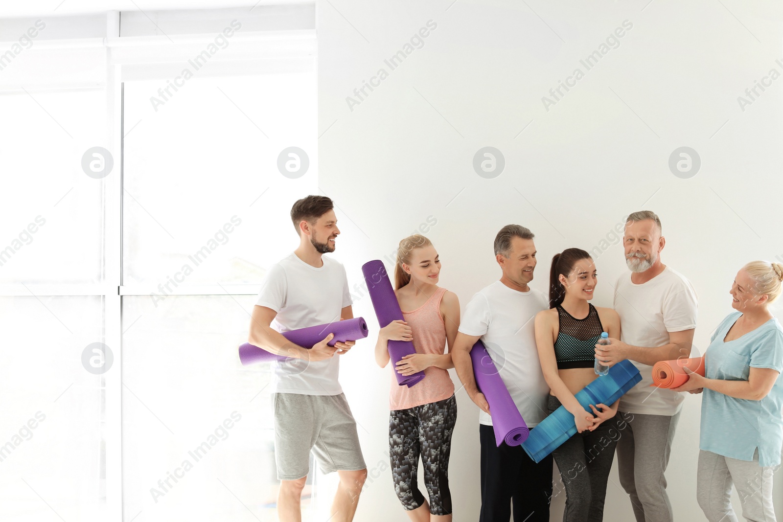 Photo of Group of people talking after yoga class indoors