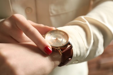 Photo of Woman wearing luxury wristwatch, closeup of hand