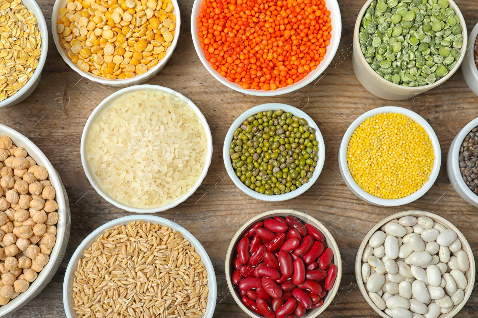 Photo of Different grains and cereals on wooden table, flat lay