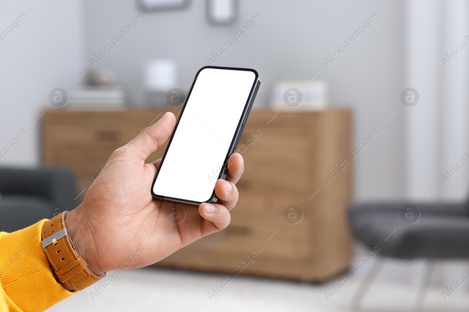 Photo of Man using modern mobile phone indoors, closeup