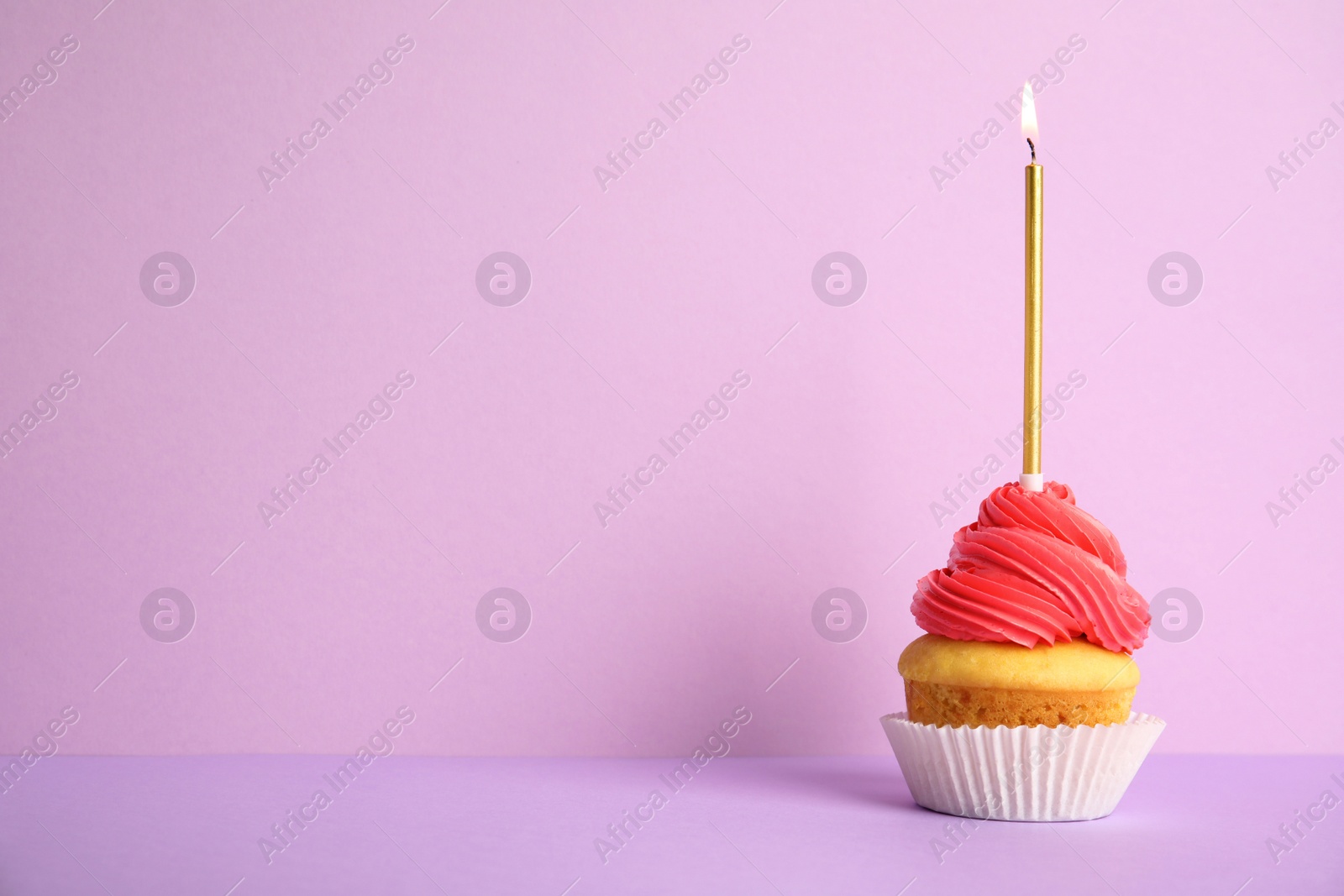 Photo of Birthday cupcake with candle on violet background, space for text