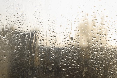 Photo of Blurred view of city from window on rainy day