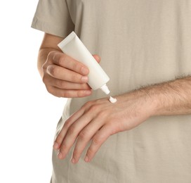 Man applying cream onto hand against white background, closeup