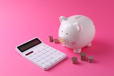 Photo of Financial savings. Piggy bank, coins and calculator on pink background
