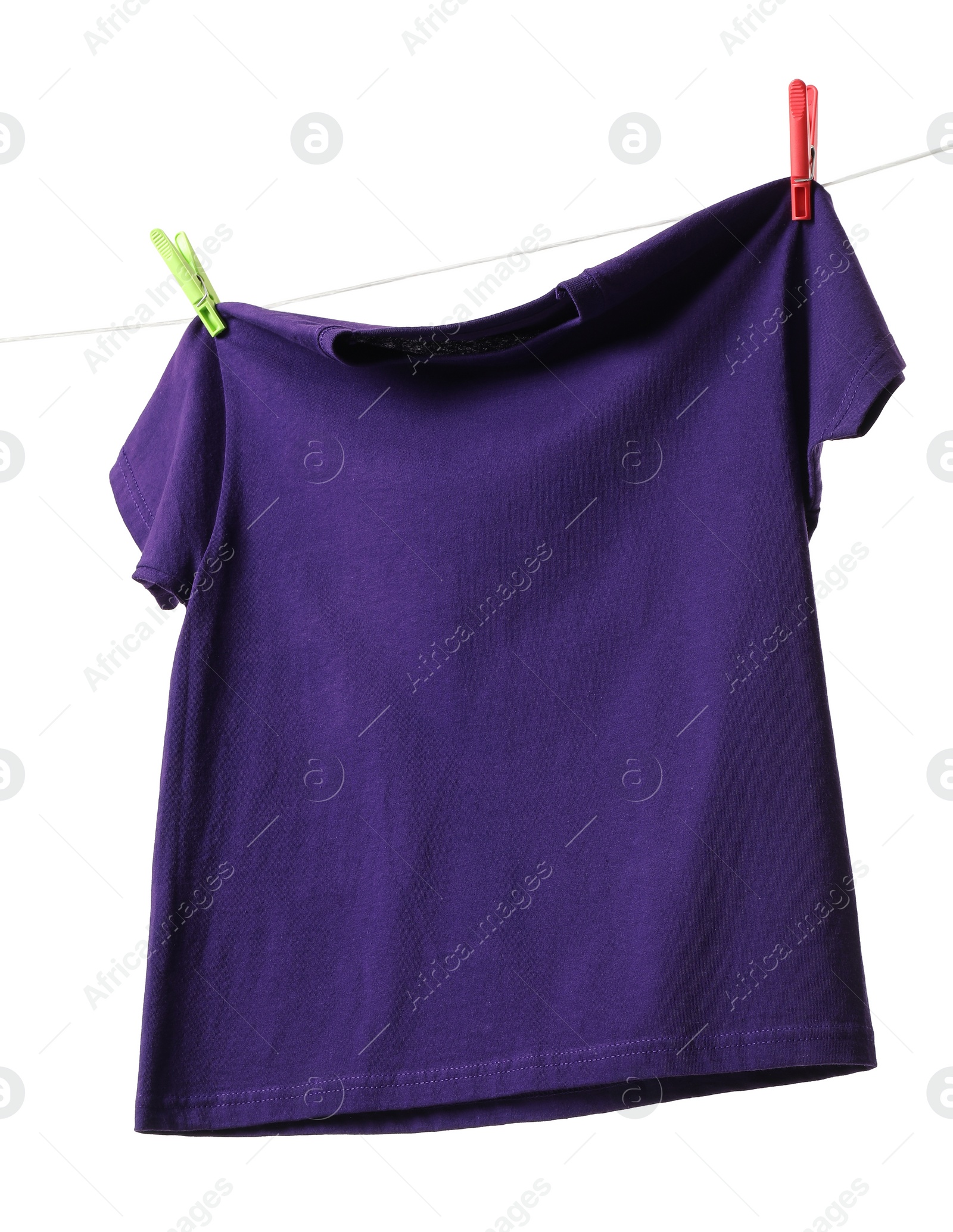 Photo of One purple t-shirt drying on washing line isolated on white