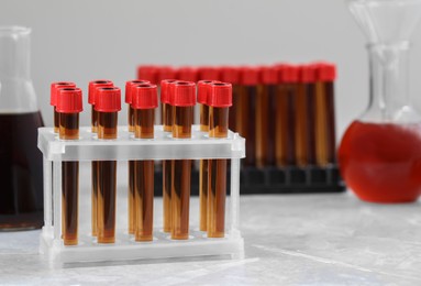 Different laboratory glassware with brown liquids on white table. Space for text