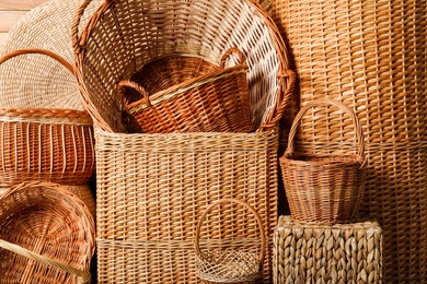 Photo of Many different wicker baskets made of natural material as background, closeup