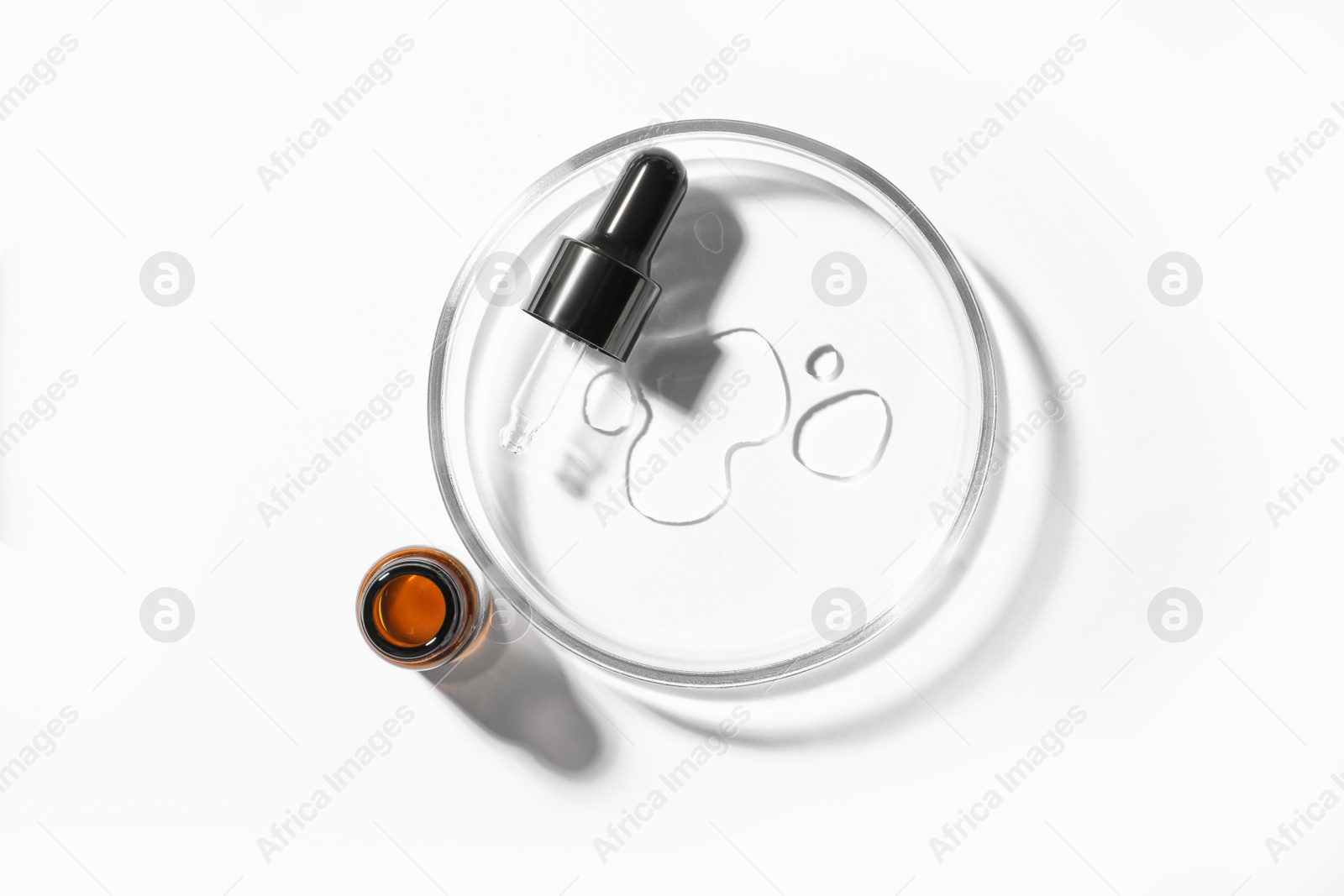Photo of Petri dish with pipette and bottle on white background, top view