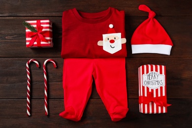 Photo of Flat lay composition with cute Christmas baby clothes on wooden background