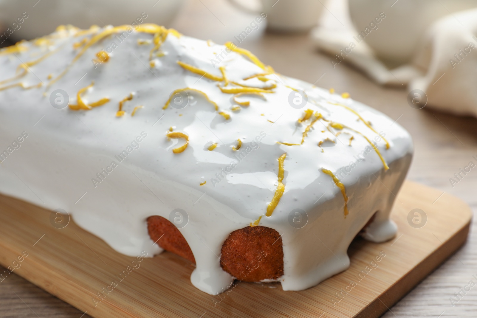 Photo of Tasty lemon cake with glaze on wooden table, closeup