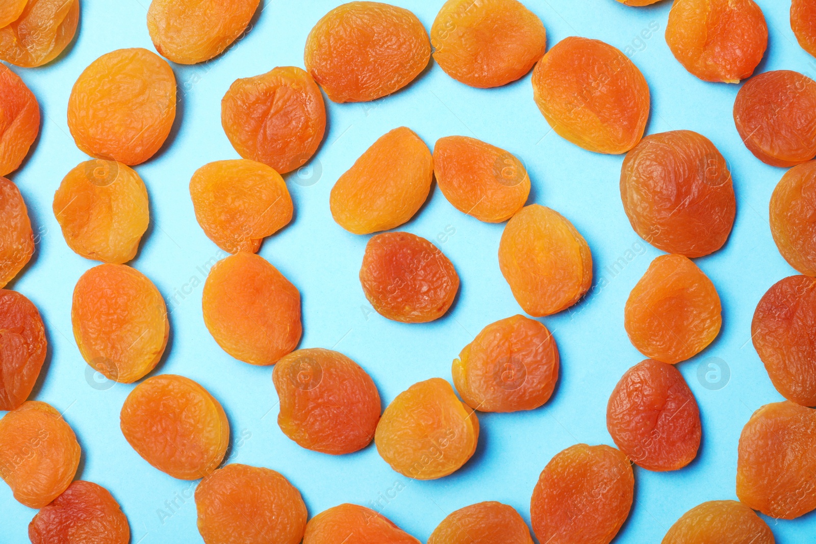 Photo of Flat lay composition with dried apricots on  color background. Healthy fruit