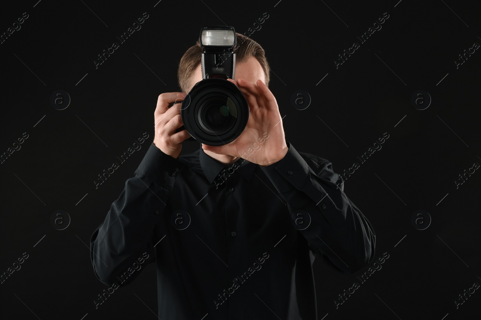 Photo of Professional photographer taking picture on black background