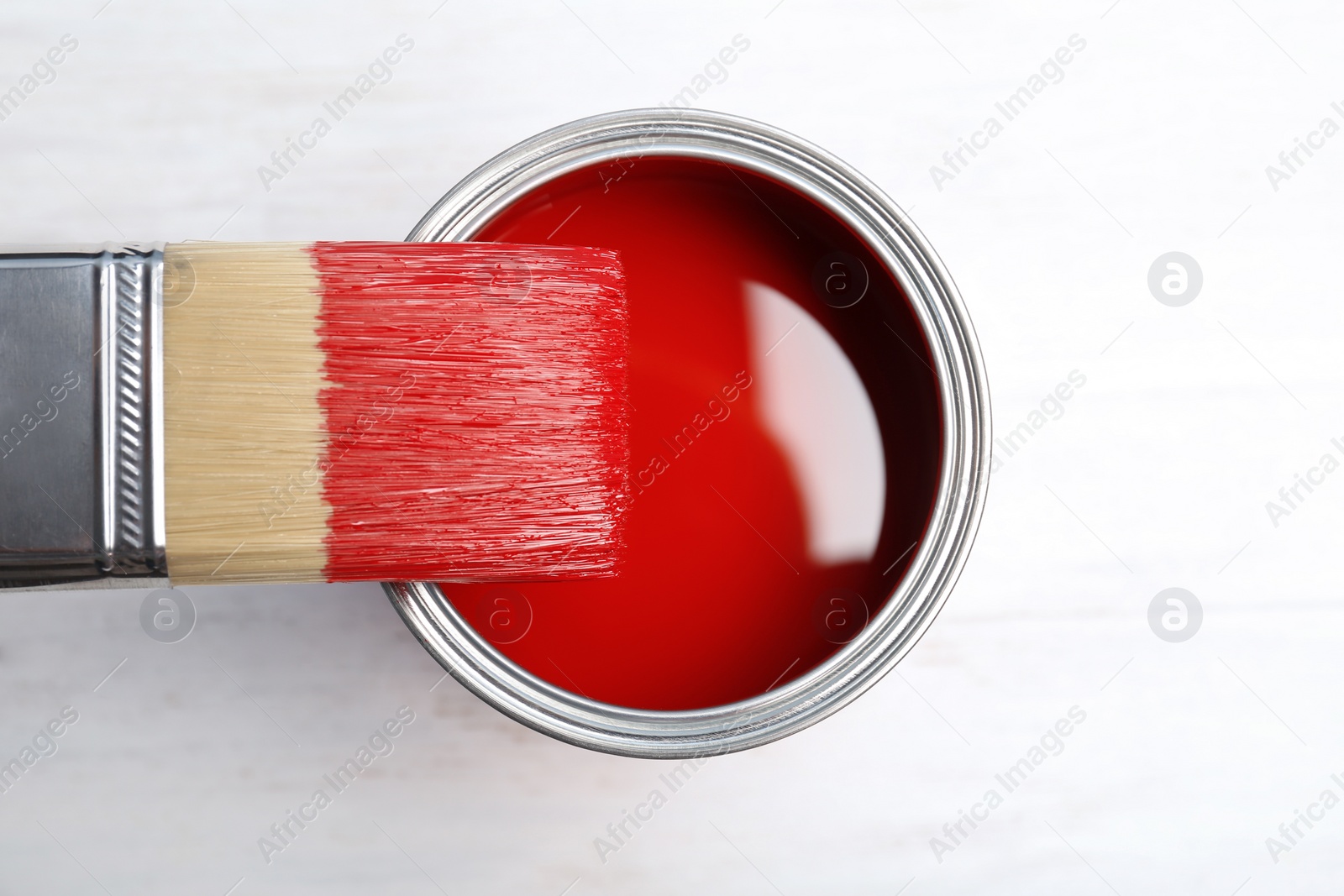 Photo of Paint can and brush on wooden background, top view