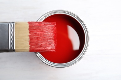 Photo of Paint can and brush on wooden background, top view