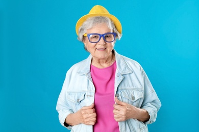 Photo of Portrait of mature woman in hipster outfit on color background