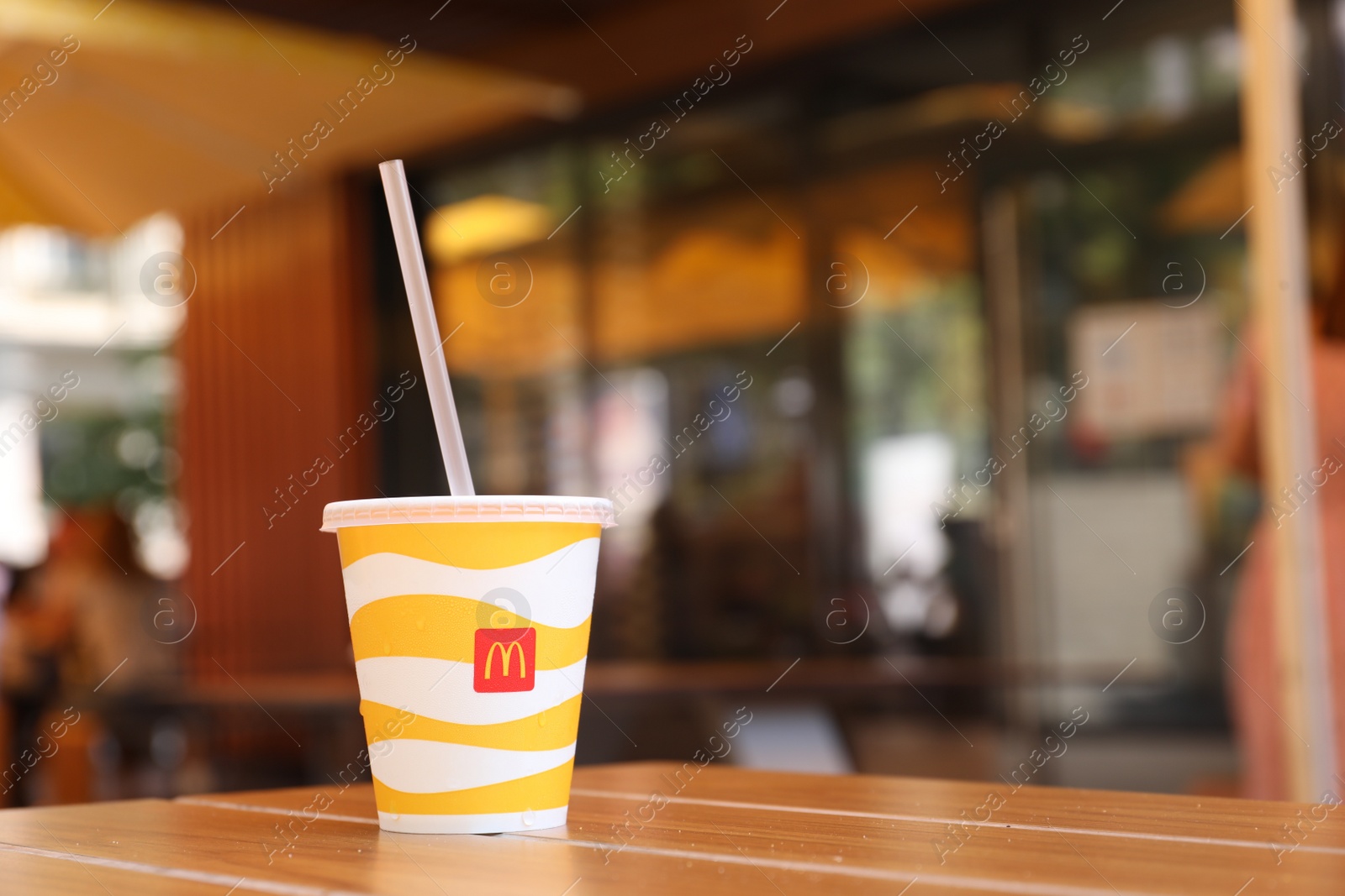 Photo of MYKOLAIV, UKRAINE - AUGUST 11, 2021: Cold McDonald's drink on table in cafe. Space for text