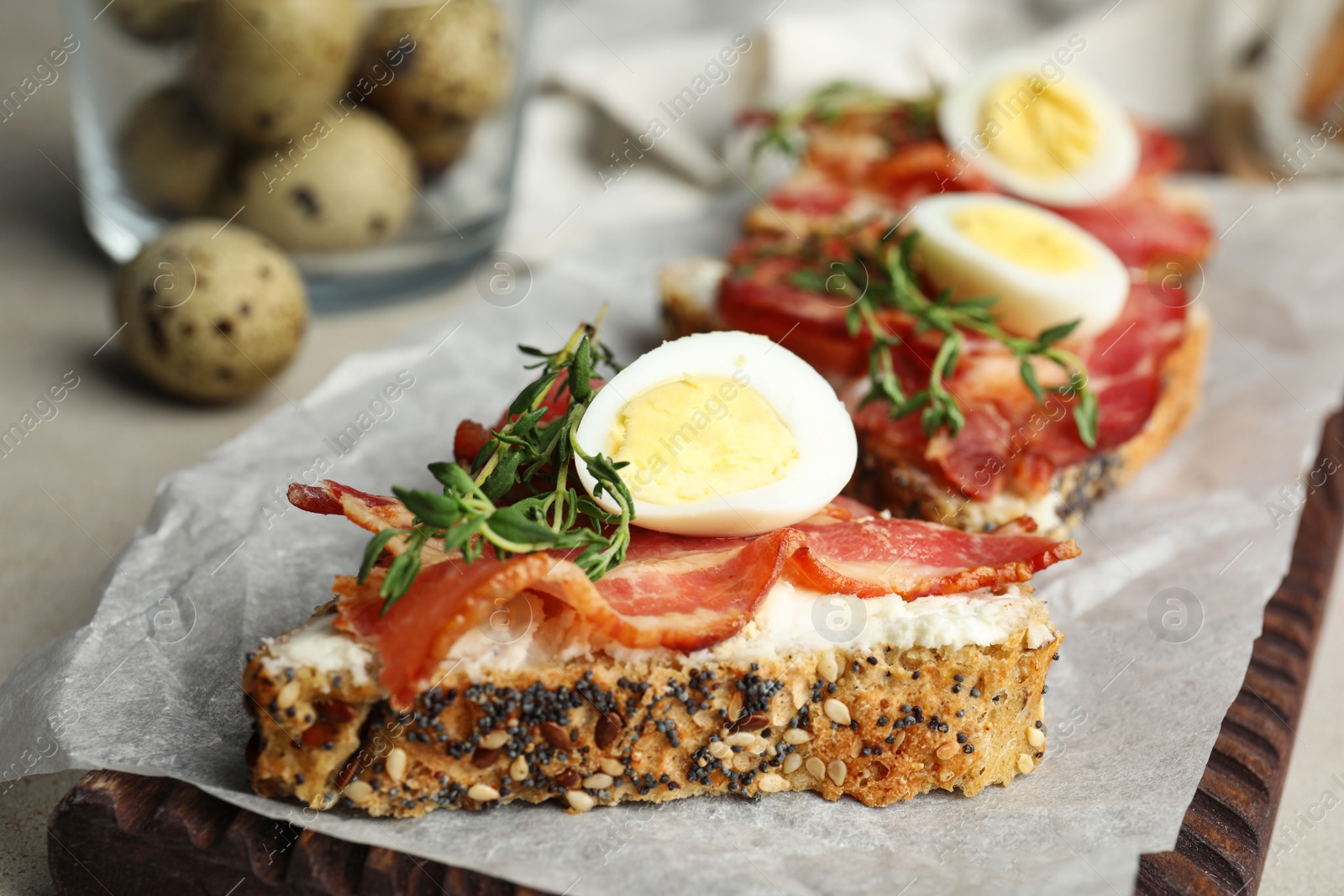 Photo of Cutting board of delicious bruschettas with prosciutto on table