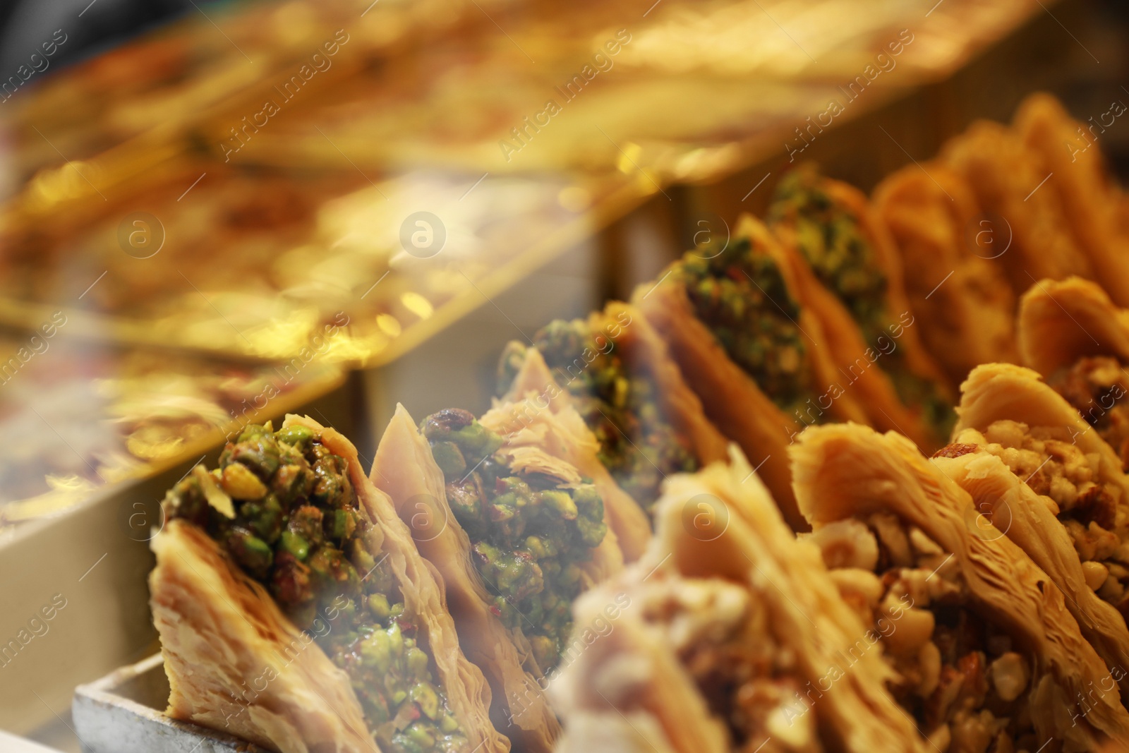 Photo of Closeup view of turkish pastries in shop through window glass