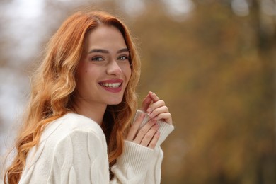 Autumn vibes. Portrait of smiling woman outdoors. Space for text