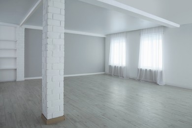 Photo of Empty room with large windows and laminated floor