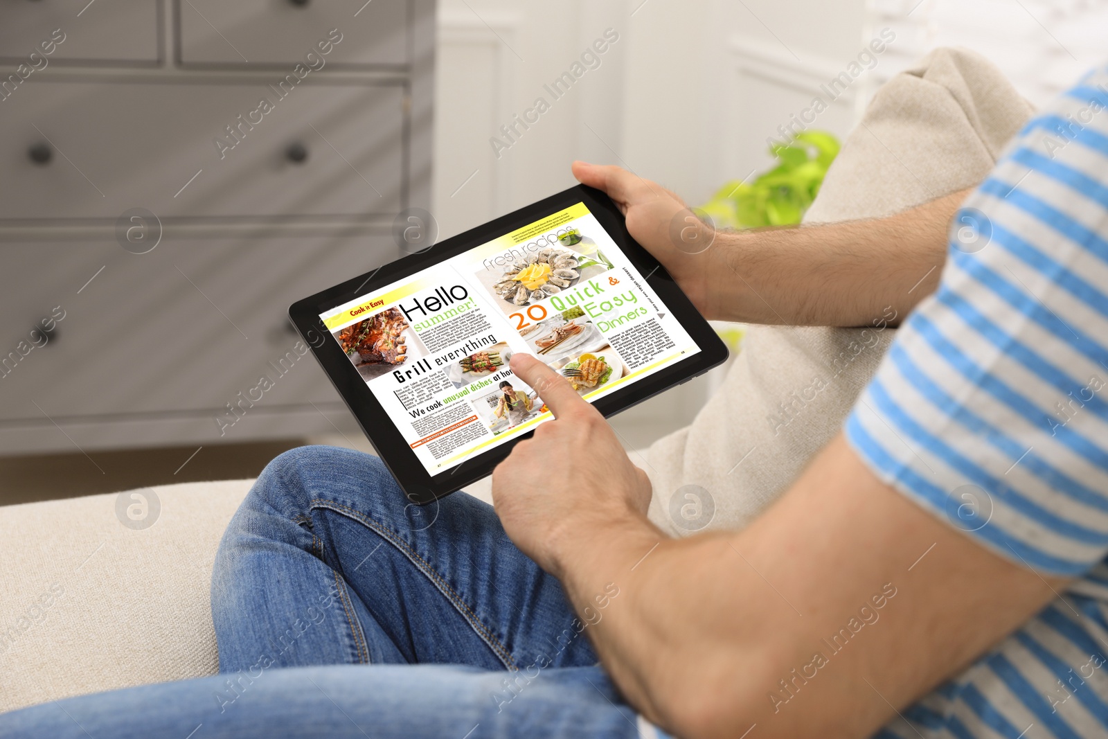 Photo of Man reading online magazine on tablet indoors, closeup